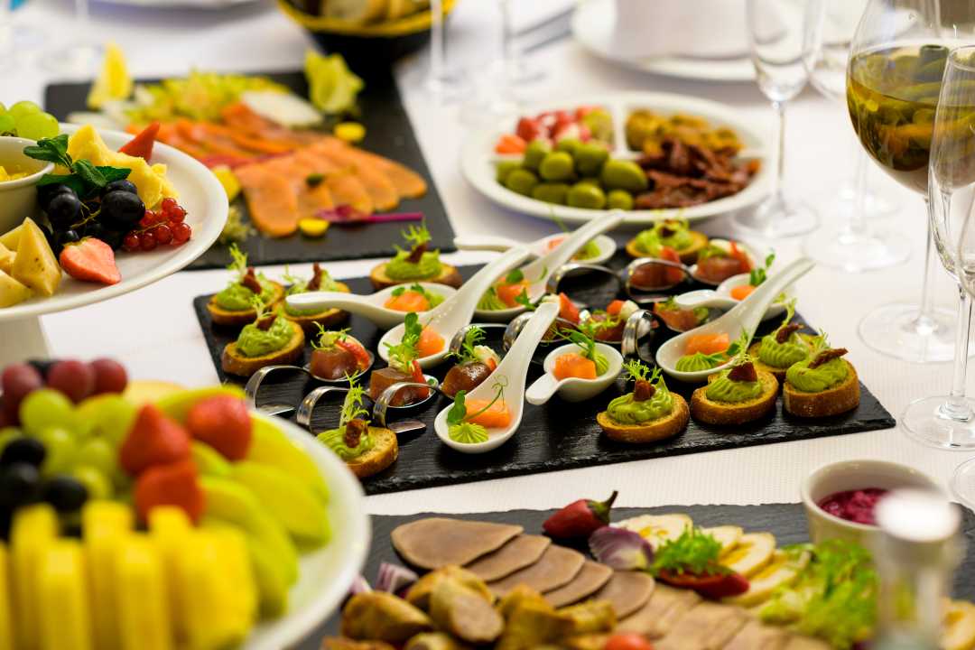 Trays of finger foods on a white table.