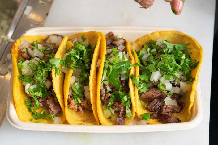 Three beef tacos on a styrofoam tray.