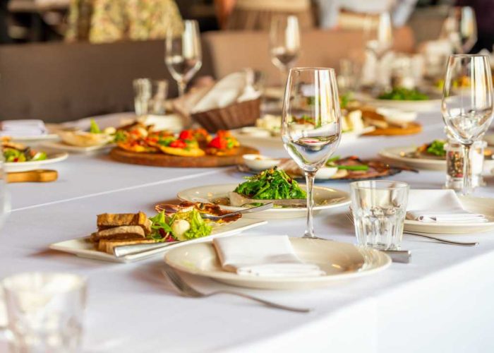 A banquet table with glasses of wine and various appetizers - Corporate Dining & Wellness​ from Guardian Refresh